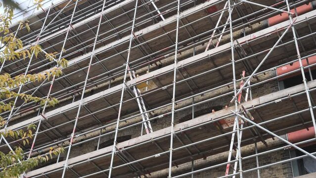 A low angle view of the block of flats covered in scaffolding.