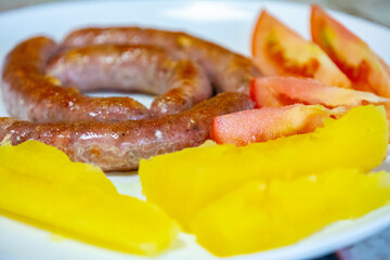Traditional rustic Brazilian food, sausage with cassava and tomatoes