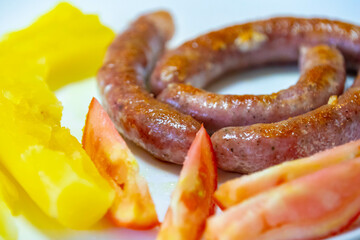 Traditional rustic Brazilian food, sausage with cassava and tomatoes