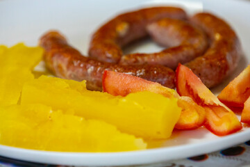 Traditional rustic Brazilian food, sausage with cassava and tomatoes