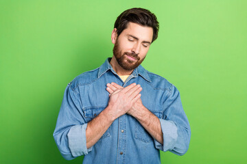 Photo of cheerful positive guy dressed jeans shirt arms ches closed eyes empty space isolated green...