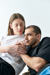 Two men sitting together on a bed.