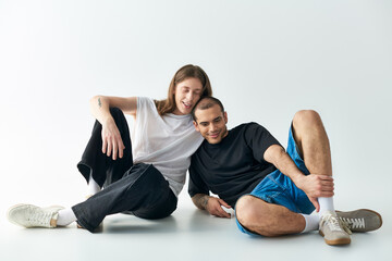 Obraz premium Two men sitting closely on the ground, sharing a loving moment.