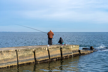 Fishermen on the pier catch fish - 795531378