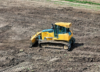 Bulldoser excavator moving dirt around to level out a field