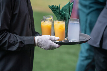 Glasses of juice being served at an event