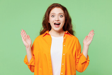 Young surprised shocked excited cool fun ginger woman she wears orange shirt white t-shirt casual...