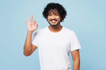 Young smiling happy fun Indian man he wear white t-shirt casual clothes showing okay ok gesture...