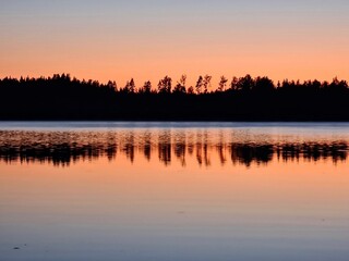 Lake at Dusk: As the day ends, the sky turns a deep shade of orange, casting a peaceful reflection on the water's surface