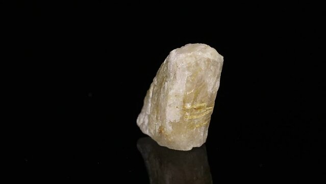 Polished mineral stone Rutile in quartz in zoisite rotates in a circle on a black background