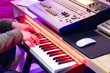 male professional music producer, composer, musician hands playing midi piano for recording in home...