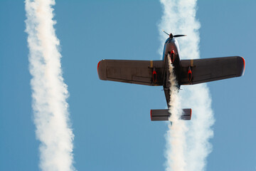 Small plane flying with smoke at an airshow.