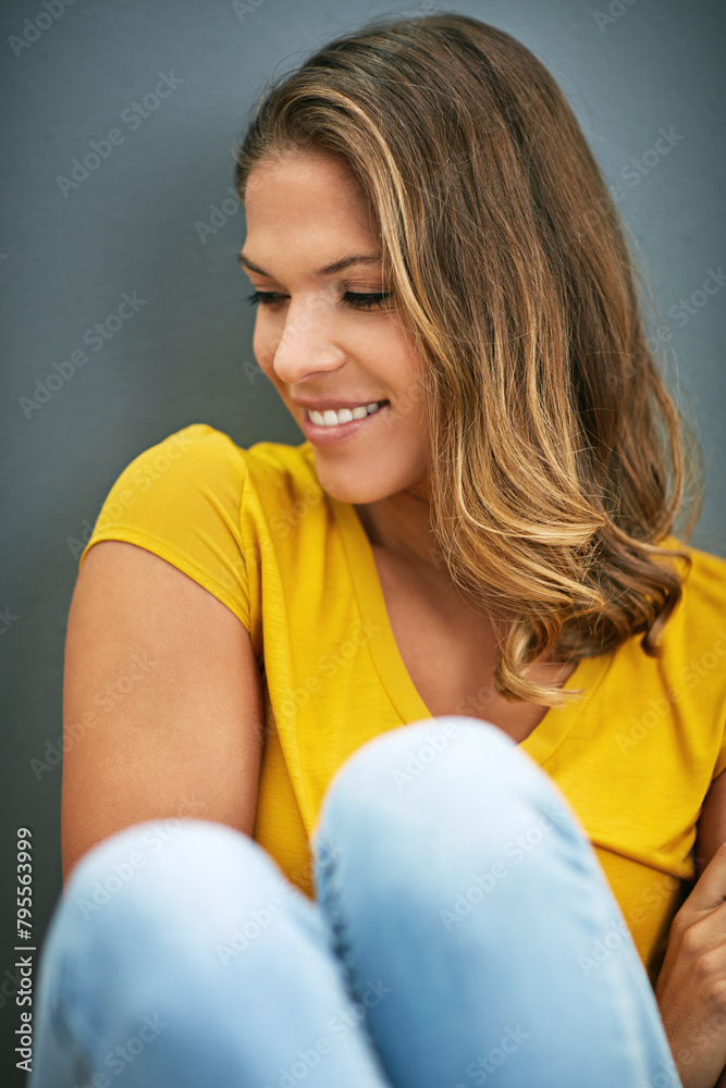 Sticker Wall, weekend and woman on floor, rest and relax for with smile, Gen z and streetwear for fashion in house. Grey background, happiness and girl in apartment, cheerful and comfortable on ground