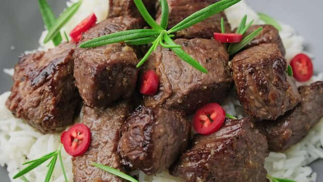 Garlic butter beef steak bites with rice. Rotating video