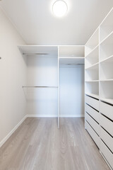 A Small White Walk in Closet With Shelves. Home Interior