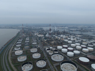 Aerial drone overview view on refinery in the port of Antwerp. Processing of fossil fuels. Petroleum industry at dusk. Heavy industrial installation. Silos containers and smokestacks. Antwerp, Belgium © Sepia100