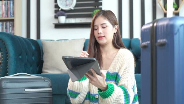 Asian happy young woman planning vacation travel and payment for flight ticket booking hotel online using laptop at home. getting ready for journey , Vacation traveling concept.