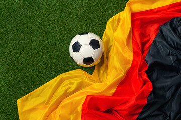 German soccer ball and flag with green grass copy space.