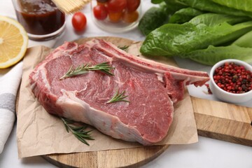 Raw meat, rosemary and products on white table, closeup