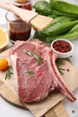 Raw meat, rosemary and products on white table, closeup