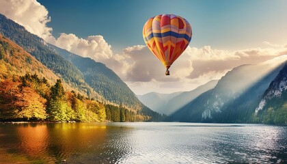 Hot air balloon over mountain lake 