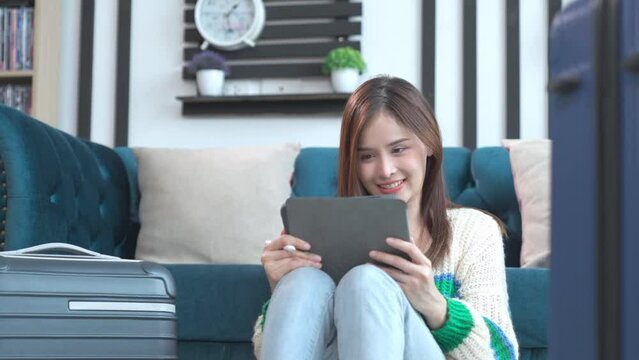 Asian happy young woman planning vacation travel and payment for flight ticket booking hotel online using laptop at home. getting ready for journey , Vacation traveling concept.