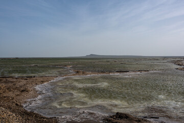 landscape of the Baskunchak salt lake with infrastructure for salt extraction on a sunny spring day