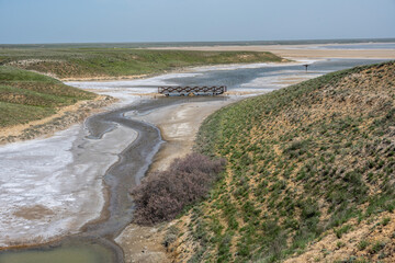 landscape of the Baskunchak salt lake with infrastructure for salt extraction on a sunny spring day