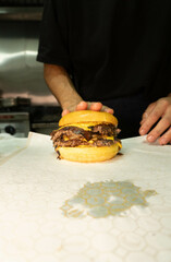 person smashing a doble cheese burger