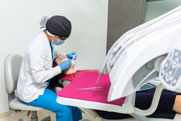Dental female patient laying down in dentist chair having teeth checked in a appointment in...