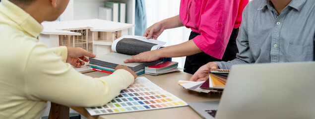 Skilled interior design team carefully selecting curtain materials while coworker selecting the...