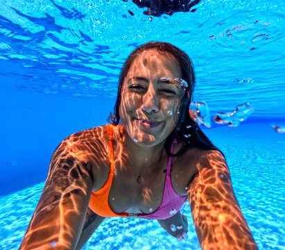 Underwater fun with a smiling woman swimming at the beach