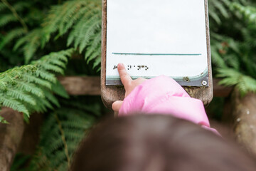 child exploring Braille signage on nature trail