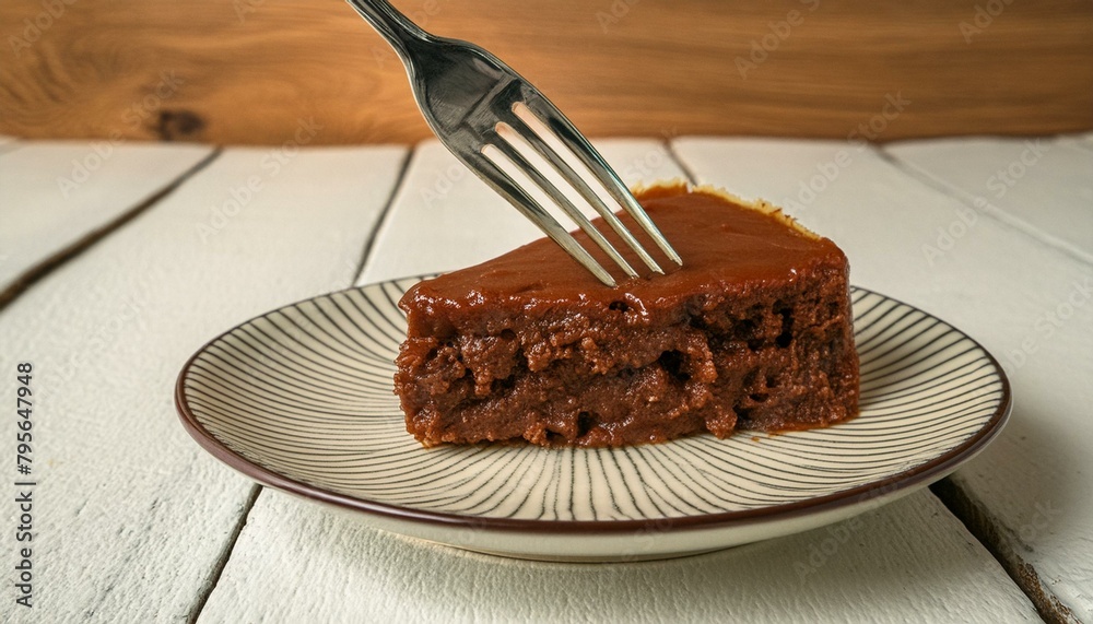 Wall mural a slice of chocolate cake on a dessert plate. fork in the composition. white wooden table.