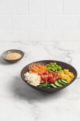 poke bowl with fresh cucumbers, carrots, edamame beans, corn, rice and sesame seeds, Bowl of healthy food on white background