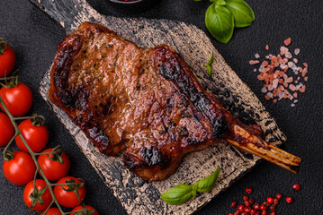 Delicious juicy beef steak on the bone, tomahawk with salt, spices and herbs