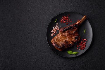 Delicious juicy beef steak on the bone, tomahawk with salt, spices and herbs