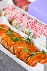 Sushi roll Philadelphia with salmon, smoked eel, avocado, cream cheese on black background. Sushi menu. Japanese food.