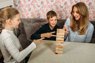Woman and Two Children Playing With Wooden Block Tower