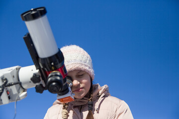 A girl looks through a solar telescope.