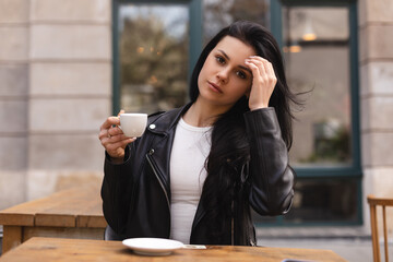 Thoughtful brunette teen woman drinking coffee in cafe outdoor, lifestyle, coffee, communication...