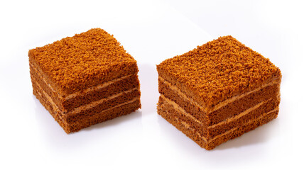 Delicate vanilla sweets lled with buttercream and candied citrus fruits topped with nut crumbs and yellow icing, presented isolated on white background