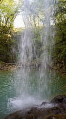  A vertical shot of Waterfall Butori with a lake on background in Istria, Croatia. Behind...
