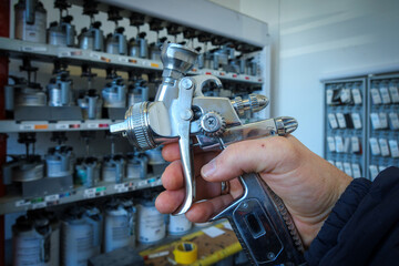 a paint spray gun is held in the hand