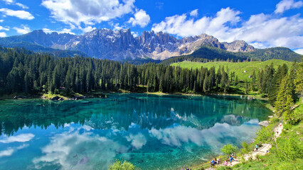 Italy Idyllic nature scenery- trasparent mountain lake Carezza surrounded by Dolomites rocks- one...