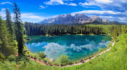 Fototapeta na wymiar Italy Idyllic nature scenery- trasparent mountain lake Carezza surrounded by Dolomites rocks- one of the most beautiful lakes of Alps. South Tyrol region.