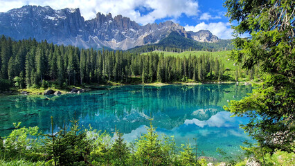 Italy Idyllic nature scenery- trasparent mountain lake Carezza surrounded by Dolomites rocks- one...