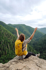 Young tourist woman  on top of a mountain. Scenery of the majestic mountains. Active lifestyle.