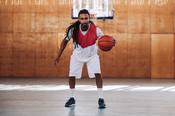 Middle eastern arabic basketball player with dreadlocks playing with a ball