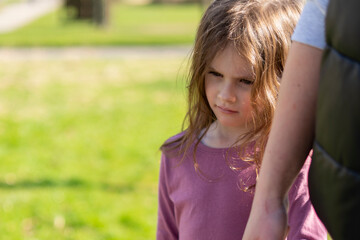 Portrait of little girl with her mother in the park on a sunny day